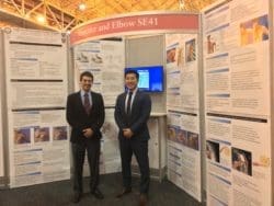 Dr. Peter S. Vezeridis standing by his presenatation at the AAOS