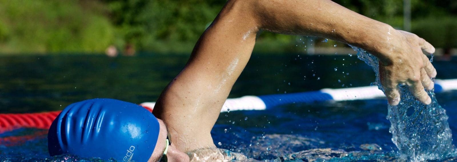 Man swimming between swim lanes on a lake