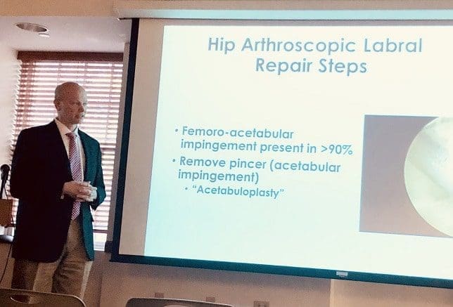 Dr. Czarnecki presenting Advances in Hip Preservation Surgery in front of screen